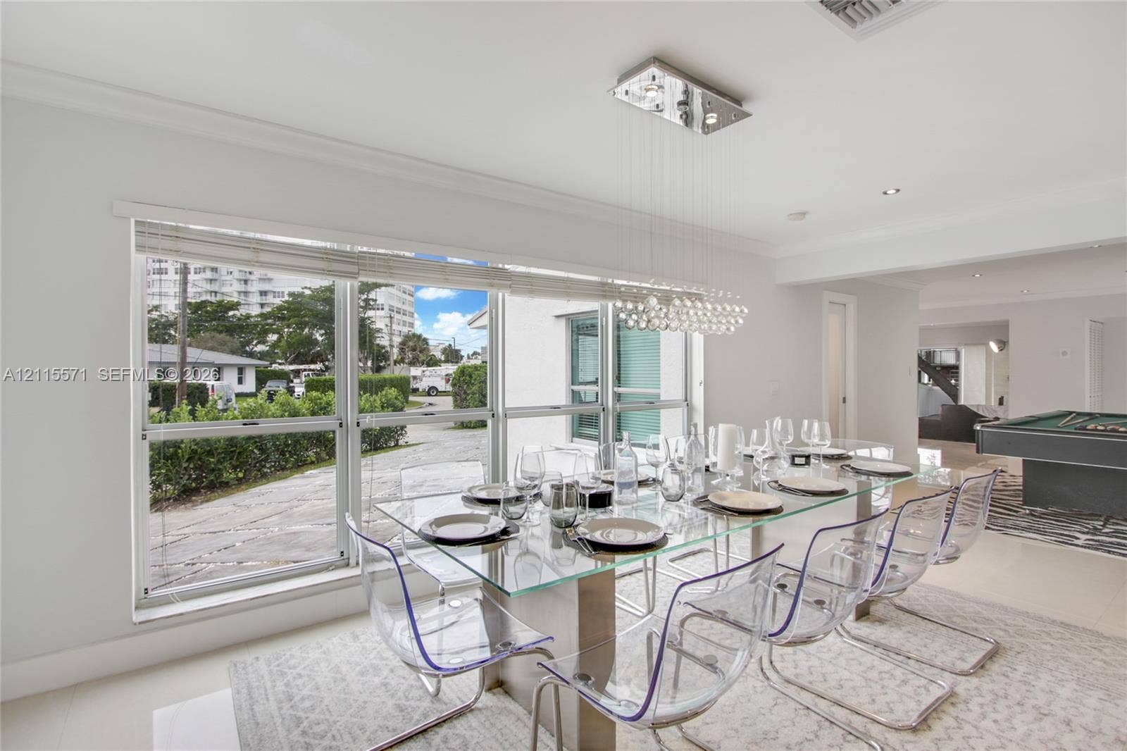 2001 NE 122nd Road, North Miami, FL 33181 Large picture windows, modern crystal sphere chandelier, recessed lighting, and crown molding
