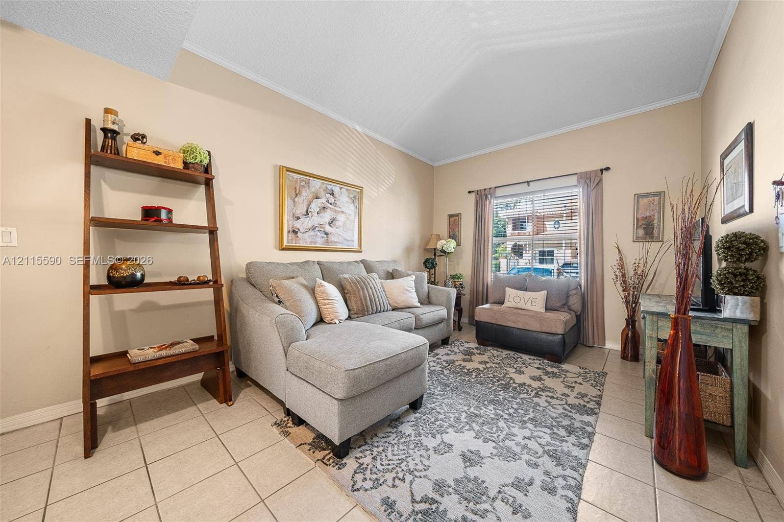 4948 Tradewinds Terrace, #504, Dania Beach, FL 33312 Vaulted ceilings, neutral wall tones, large window with horizontal blinds, and ceramic tile flooring