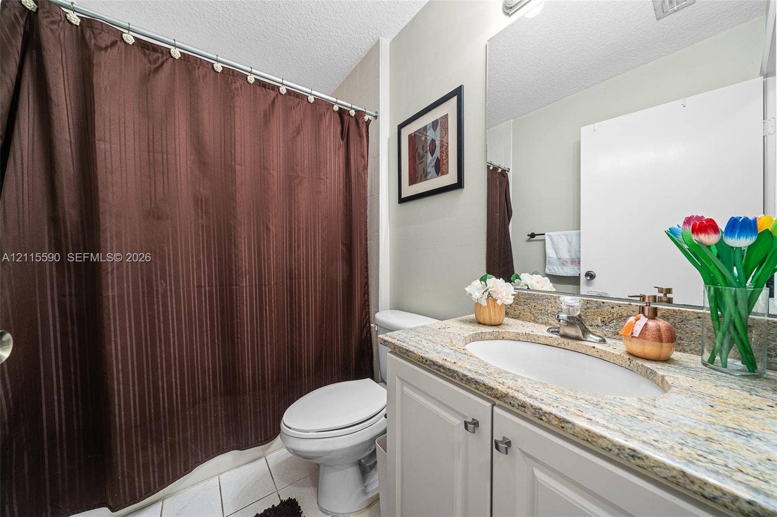 4948 Tradewinds Terrace, #504, Dania Beach, FL 33312 Bathroom featuring a vanity with stone countertop, integrated sink, white cabinetry, large wall-mounted mirror, and tile flooring