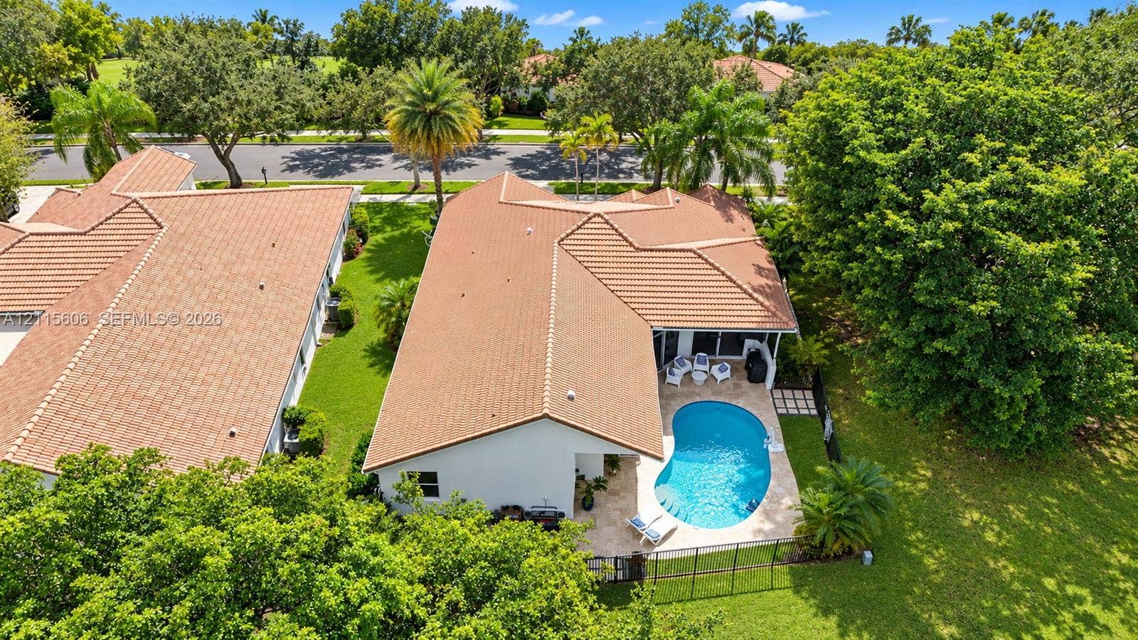 2652 Palmer Place, #2652, Weston, Weston, FL 33332 Aerial perspective of a property featuring a tile roof, an in-ground pool with a paved patio, and a landscaped lot with mature trees