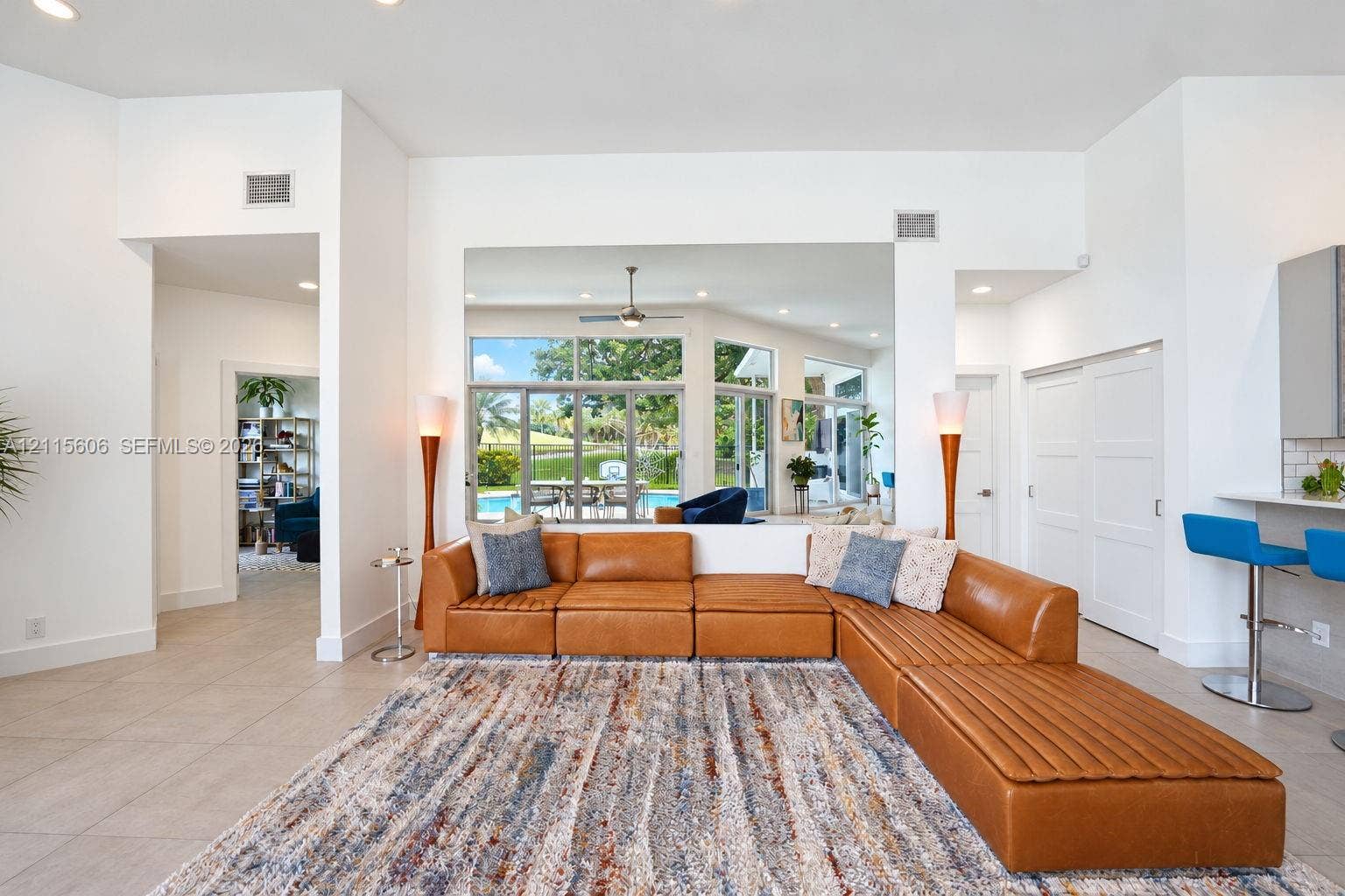 2652 Palmer Place, #2652, Weston, Weston, FL 33332 Open-concept interior featuring large-format tile flooring, recessed ceiling lighting, a ceiling fan, and sliding glass doors revealing an outdoor pool