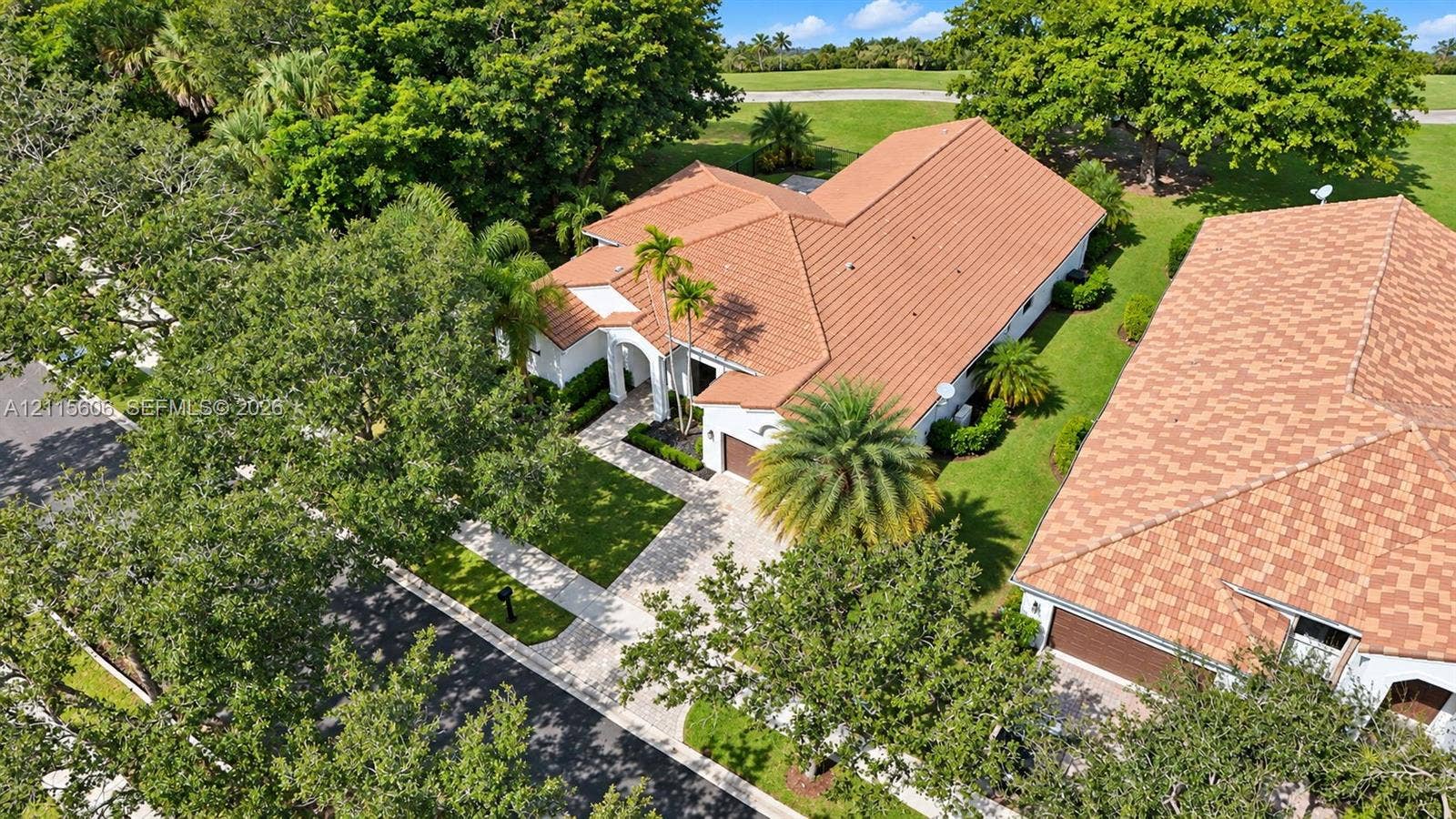 2652 Palmer Place, #2652, Weston, Weston, FL 33332 Tile roof architecture, paver driveway, manicured landscaping, and mature trees on a corner lot