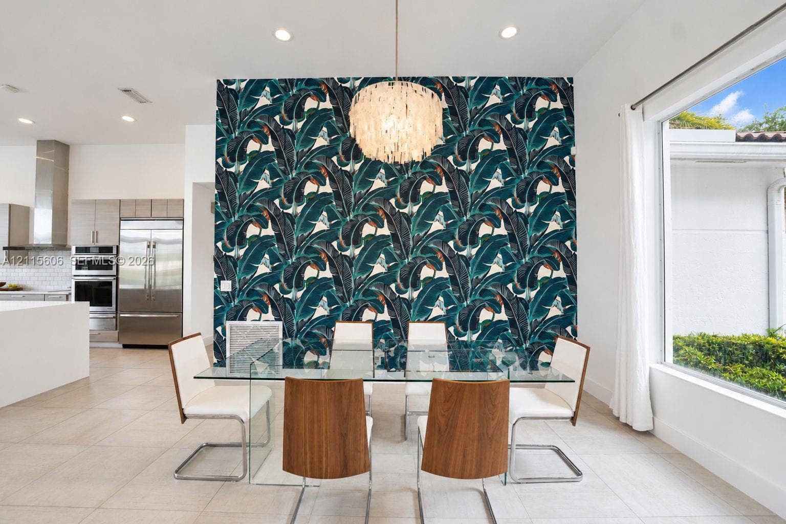 2652 Palmer Place, #2652, Weston, Weston, FL 33332 Dining area featuring a statement wall with botanical patterned wallpaper, a tiered shell pendant light, recessed ceiling lighting, large-format tile flooring, and a floor-to-ceiling window