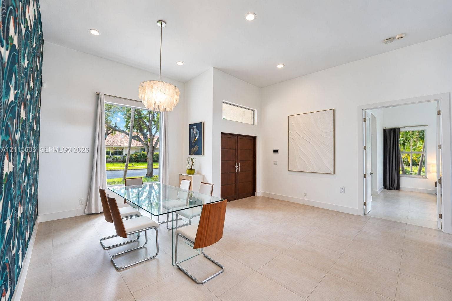 2652 Palmer Place, #2652, Weston, Weston, FL 33332 High-ceilinged room featuring large-format tile flooring, a prominent patterned accent wall, recessed lighting, and a chandelier with textured detail