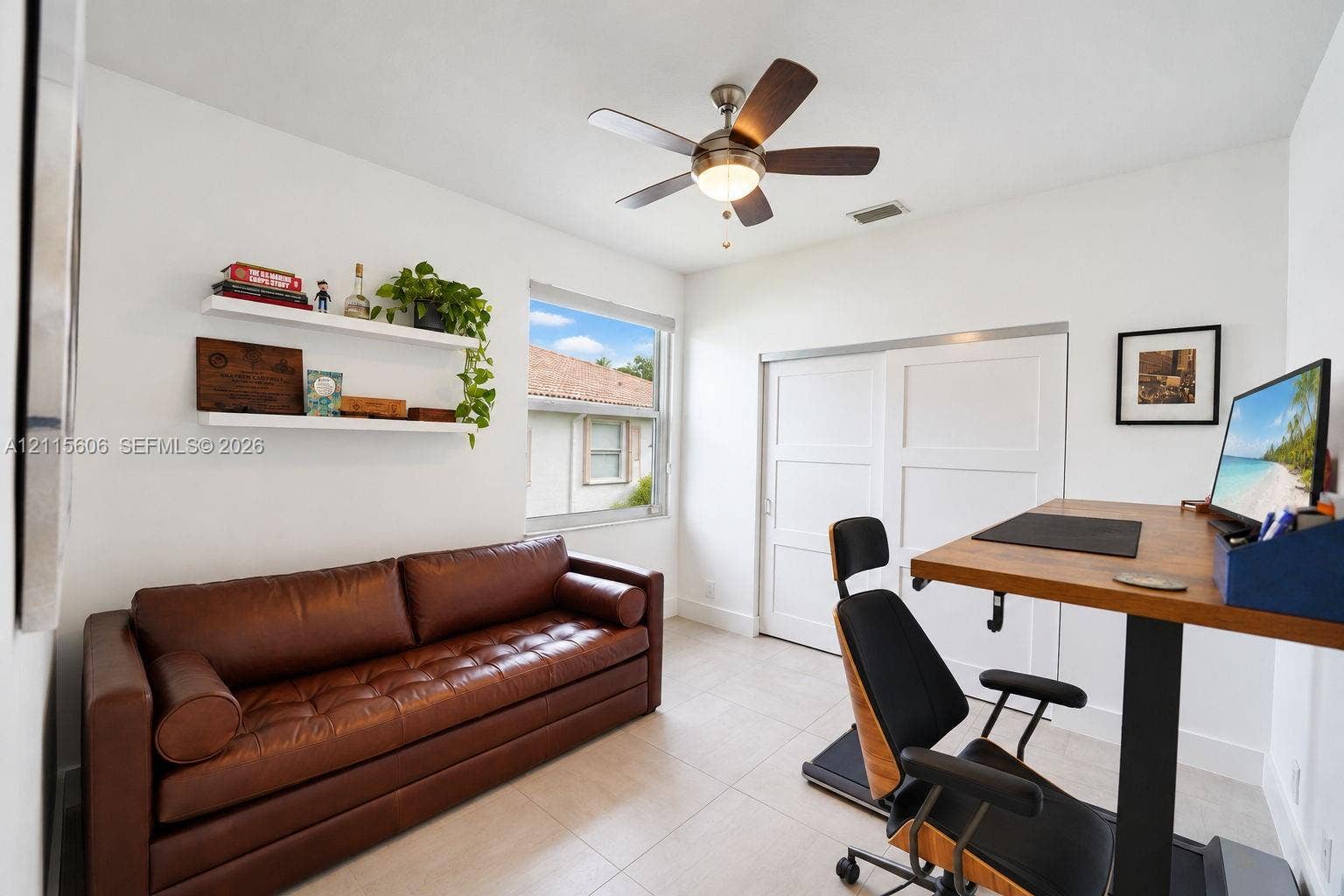 2652 Palmer Place, #2652, Weston, Weston, FL 33332 Neutral-toned tile flooring, white sliding closet doors, multi-blade ceiling fan with integrated lighting, and two wall-mounted floating shelves