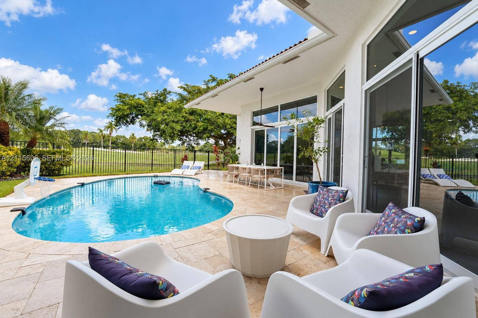 2652 Palmer Place, #2652, Weston, Weston, FL 33332 Covered patio with travertine tile flooring, inground swimming pool, floor-to-ceiling glass doors, and black metal perimeter fencing