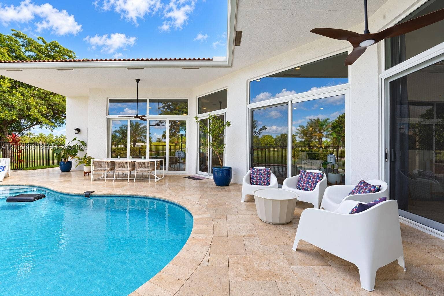 2652 Palmer Place, #2652, Weston, Weston, FL 33332 Covered patio featuring stone-tile flooring, ceiling fans, oversized glass sliding doors, and a curved swimming pool