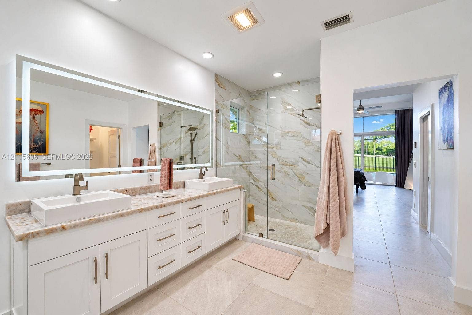 2652 Palmer Place, #2652, Weston, Weston, FL 33332 Dual-sink vanity with rectangular vessel basins, stone countertop, large LED-backlit mirror, and glass-enclosed shower with tiled wall surfacing