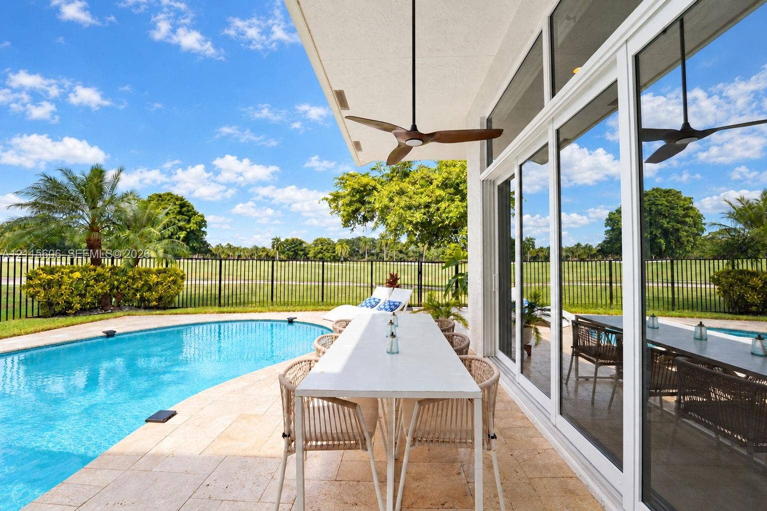 2652 Palmer Place, #2652, Weston, Weston, FL 33332 Covered lanai featuring natural stone flooring, ceiling fan, expansive glass sliding doors, private swimming pool, and wrought-iron style fencing