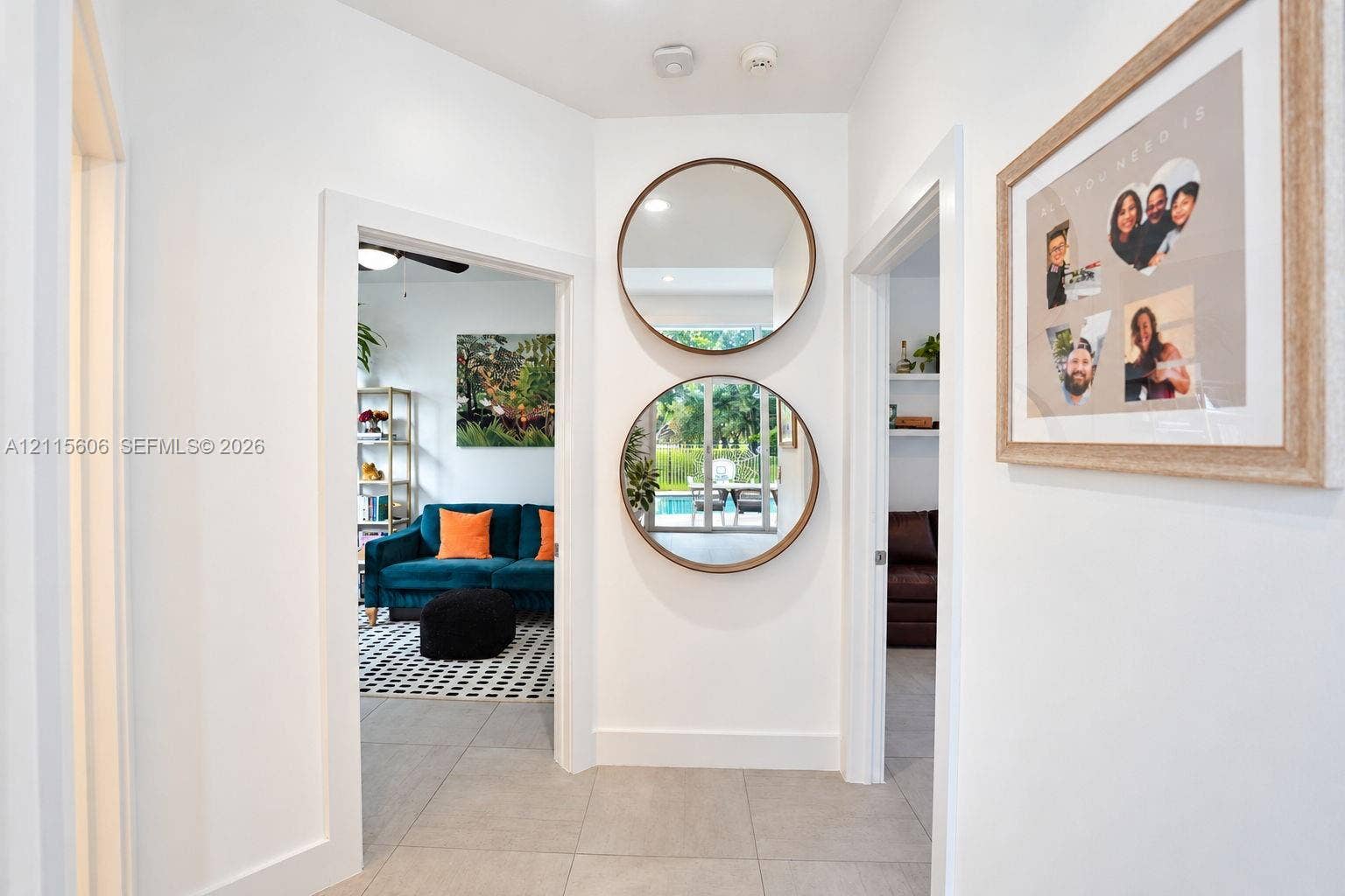 2652 Palmer Place, #2652, Weston, Weston, FL 33332 Interior hallway featuring large-format tile flooring, neutral wall finishes, and dual circular wall-mounted mirrors with wood-toned frames