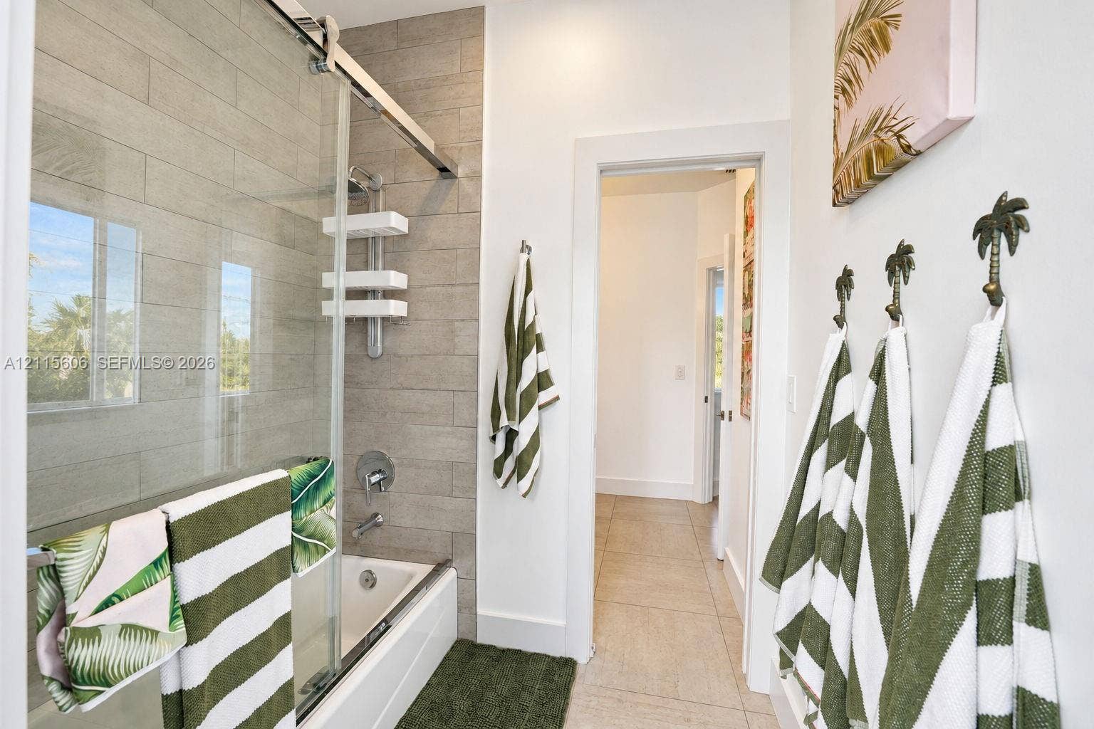 2652 Palmer Place, #2652, Weston, Weston, FL 33332 Bathroom featuring a shower-tub combination with a glass sliding door enclosure, tiled wall surround, and large-format floor tile