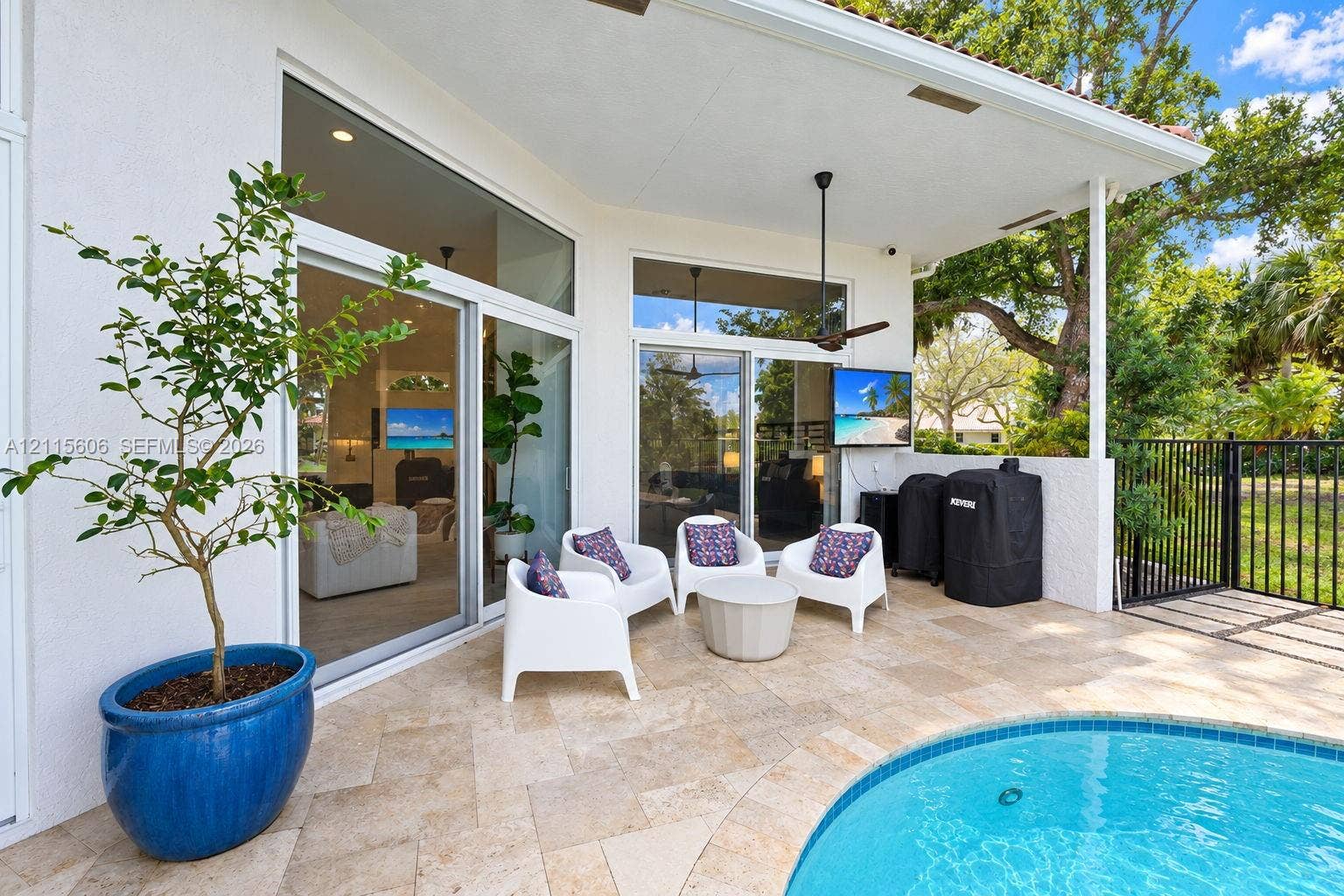 2652 Palmer Place, #2652, Weston, Weston, FL 33332 Covered patio featuring stone tile flooring, a swimming pool, multiple sliding glass door sets, and a ceiling-mounted fan