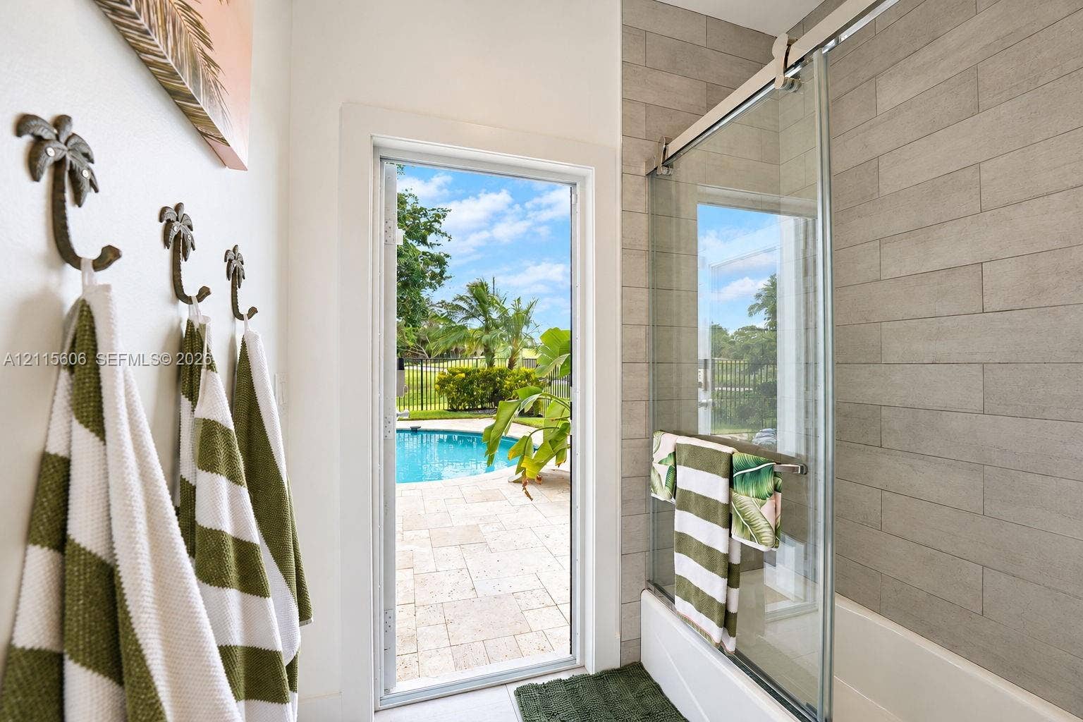 2652 Palmer Place, #2652, Weston, Weston, FL 33332 Bathroom featuring a sliding glass shower door, rectangular tile wall surround, and exterior door with access to a patio and pool