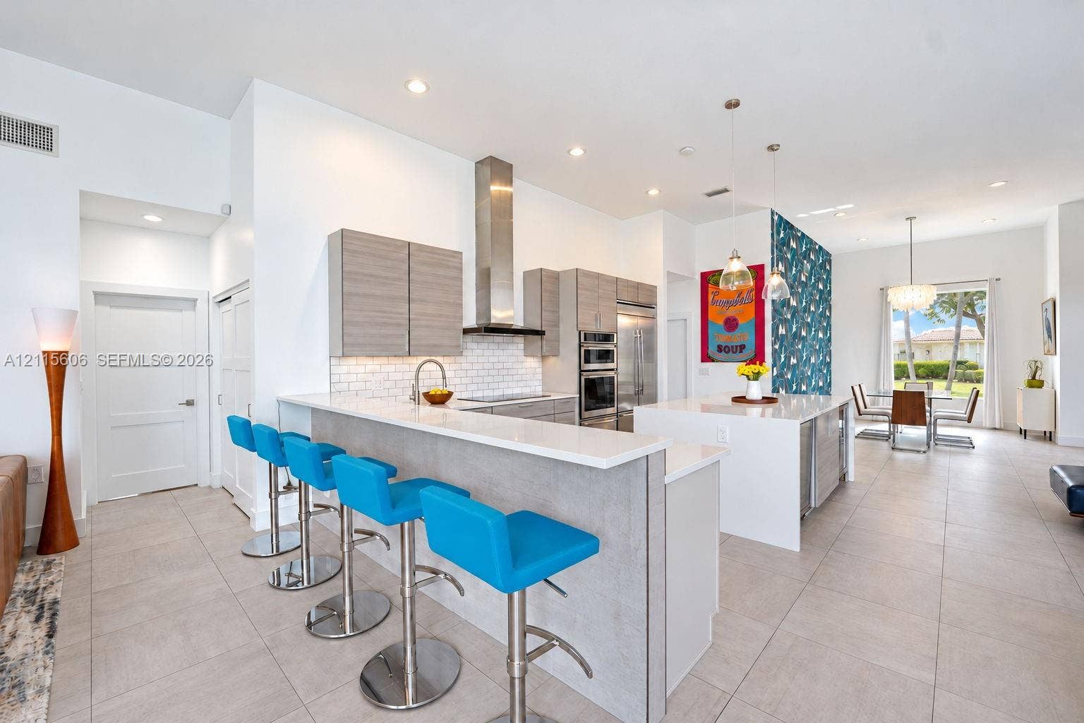 2652 Palmer Place, #2652, Weston, Weston, FL 33332 Kitchen featuring flat-panel cabinetry, a quartz-topped island with waterfall edge, stainless steel appliances, a white subway tile backsplash, and oversized floor tiles