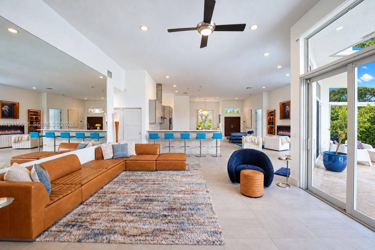 2652 Palmer Place, #2652, Weston, Weston, FL 33332 Open-concept interior featuring large-format tile flooring, expansive glass sliding doors, dual built-in fireplaces, a ceiling fan, and recessed lighting throughout