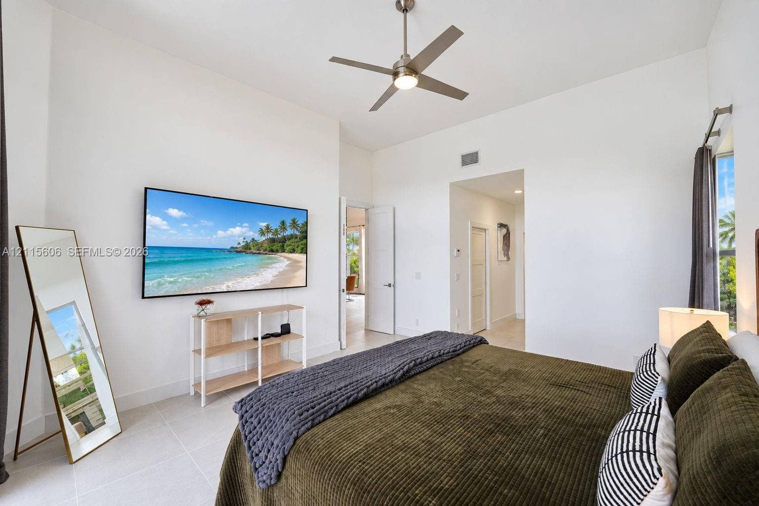 2652 Palmer Place, #2652, Weston, Weston, FL 33332 High-ceilinged room featuring neutral tile flooring, a brushed-nickel ceiling fan, and large windows with prominent natural light