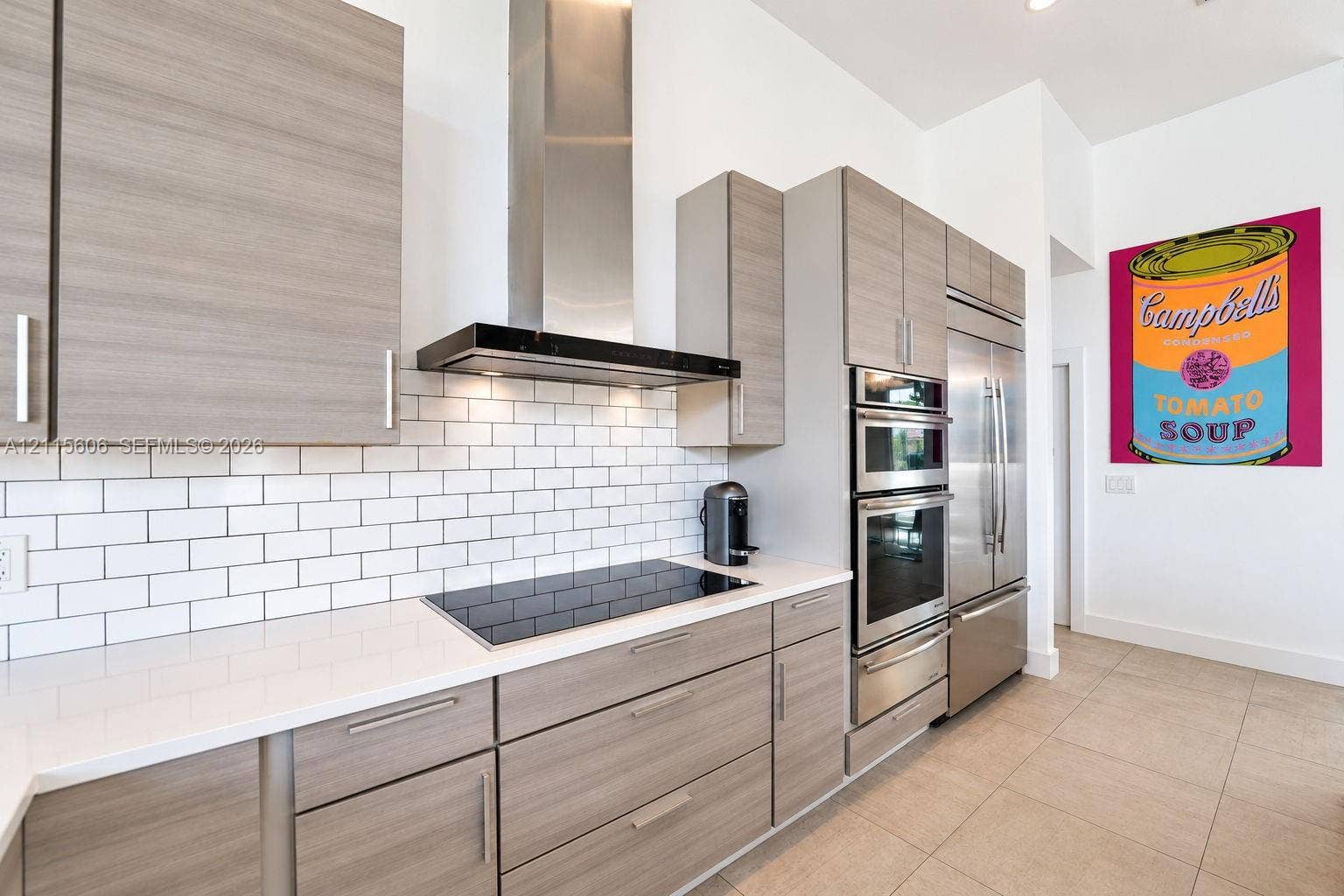 2652 Palmer Place, #2652, Weston, Weston, FL 33332 Kitchen featuring light wood-finish cabinetry, white solid-surface countertops, white subway tile backsplash, stainless steel built-in appliances, and a modern chimney-style range hood
