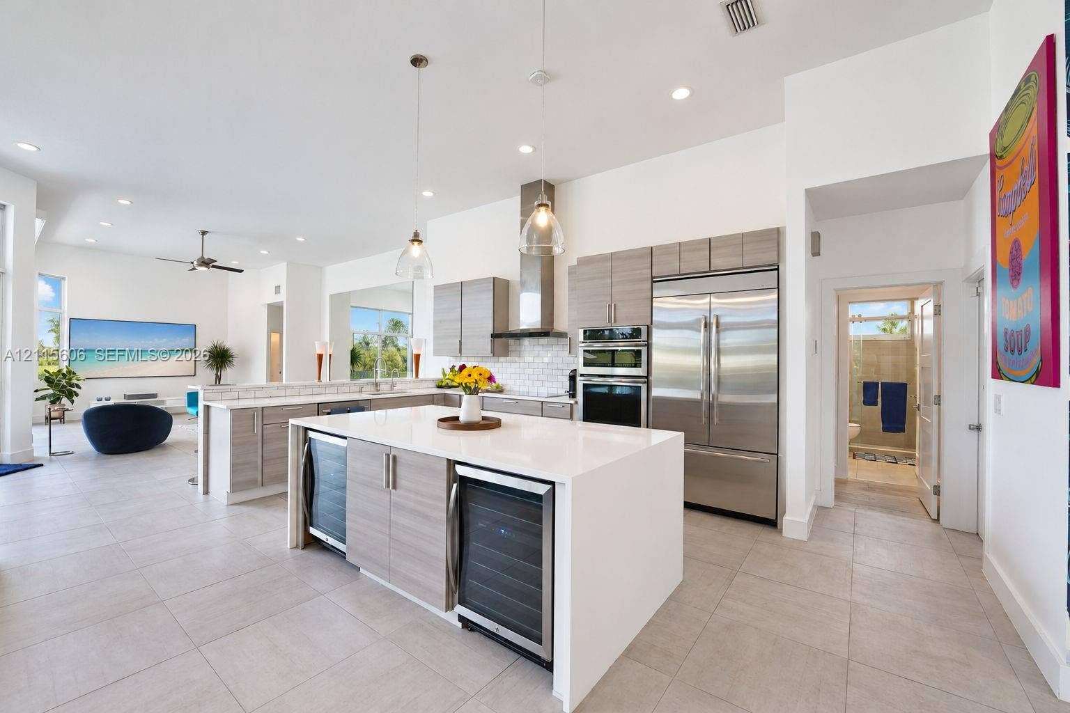 2652 Palmer Place, #2652, Weston, Weston, FL 33332 Kitchen featuring light-finish cabinetry, a large central island with a solid surface countertop, stainless steel appliances, dual beverage coolers, and pendant lighting