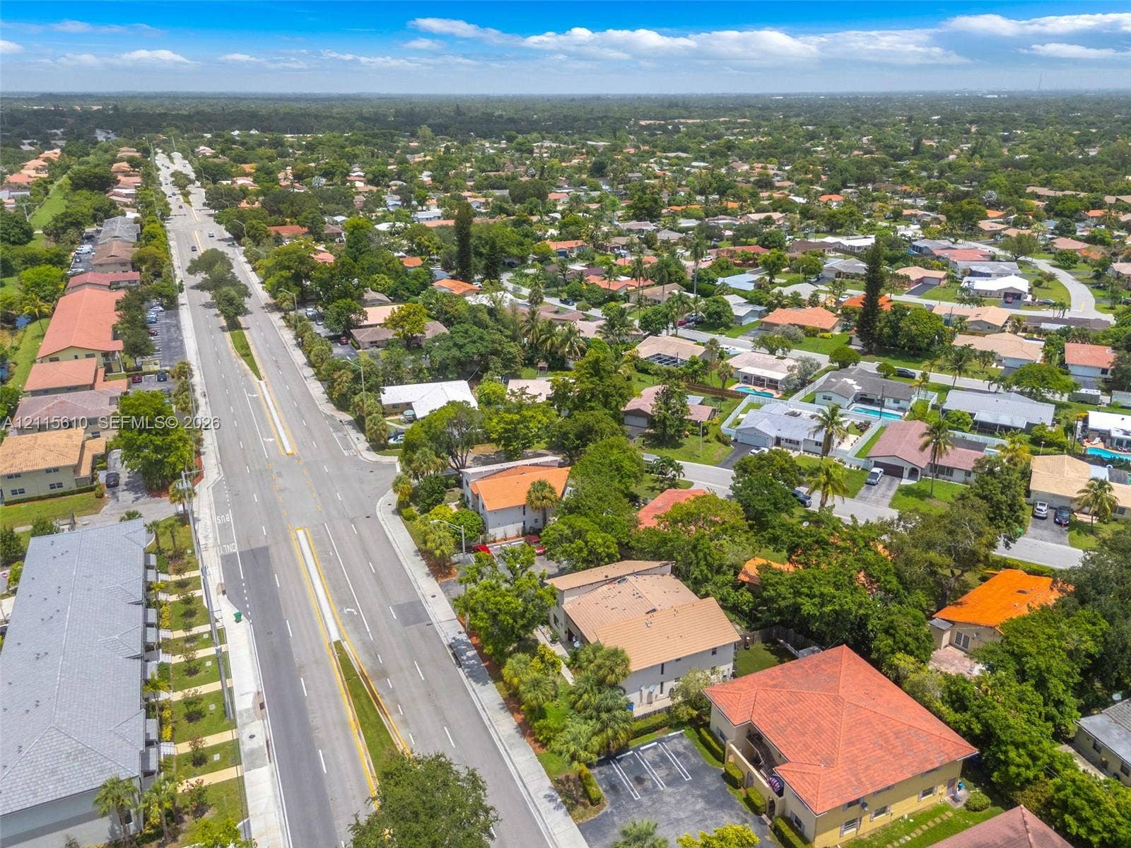 3711 Riverside Drive, Coral Springs, FL 33065 Aerial perspective of a suburban neighborhood featuring paved arterial roadways, residential clusters, mature tree canopies, tiled roof architecture, and integrated surface parking