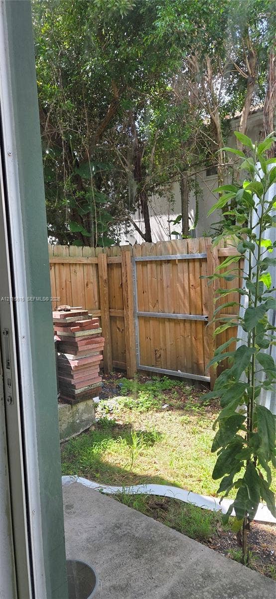 2870 SE 15th Road, #50, Homestead, Homestead, FL 33035 Concrete patio featuring a vertical wood privacy fence and mature trees