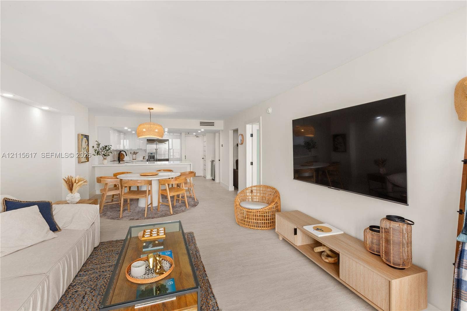 Open-concept interior featuring light wood-finish flooring, recessed lighting, and a neutral color palette