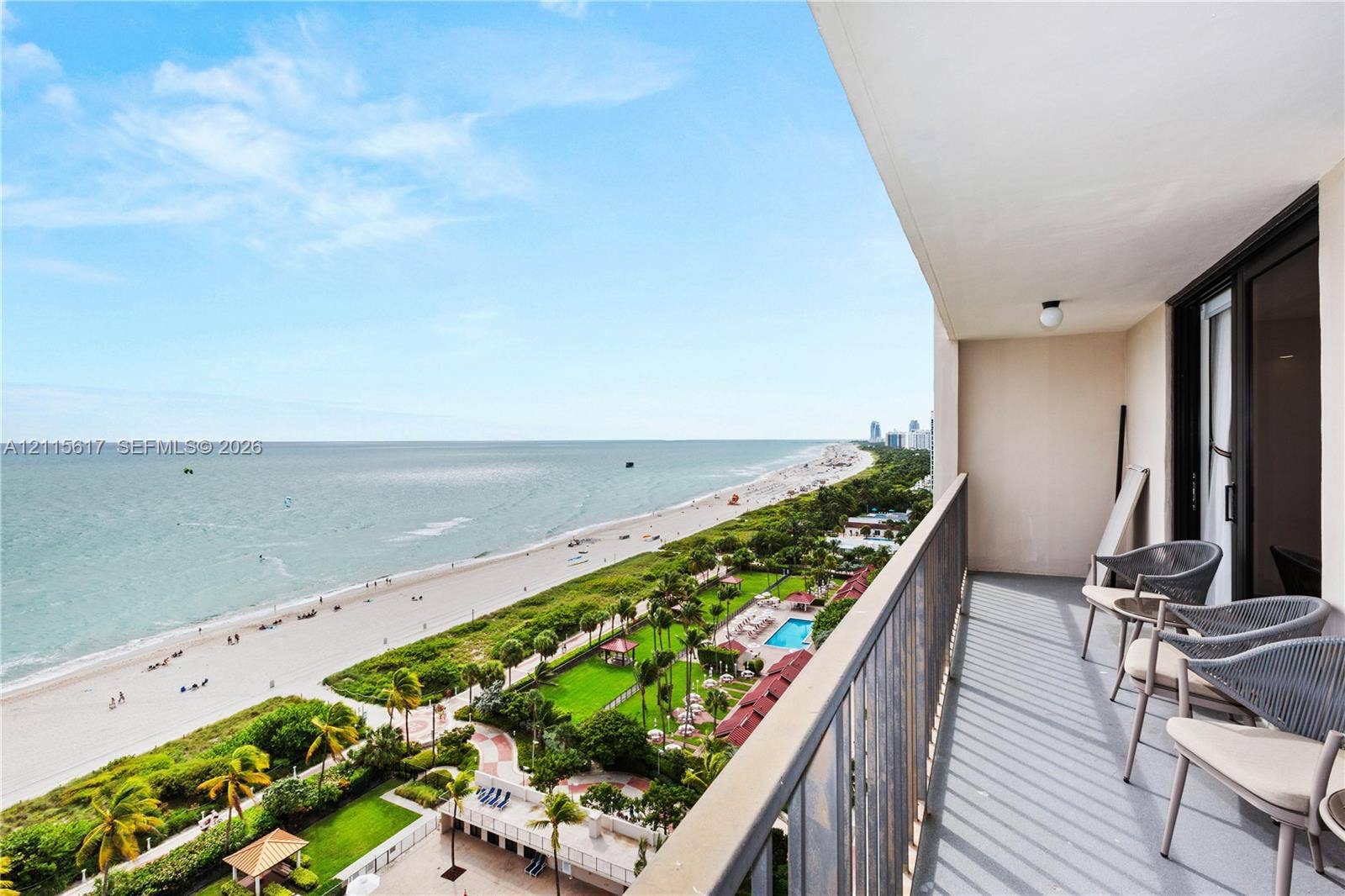 Covered balcony with metal railing, featuring expansive ocean and coastal scenery