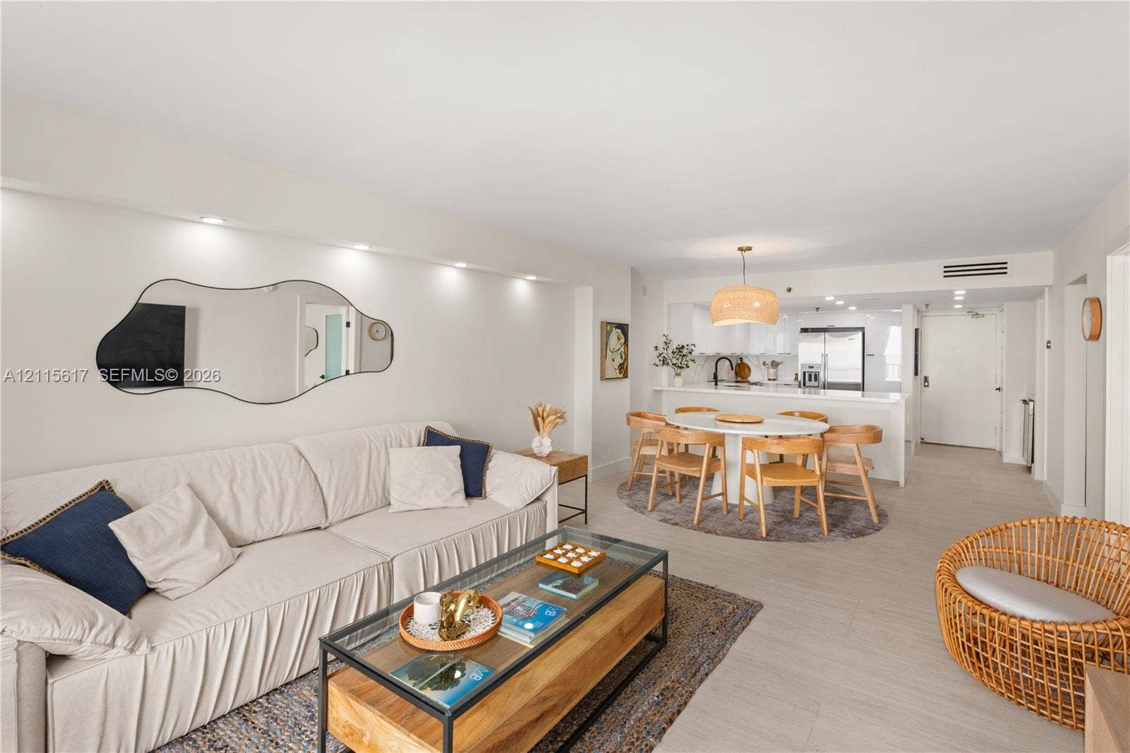 Open-concept interior featuring light-toned flooring, recessed ceiling lighting, and a kitchen peninsula with quartz countertops
