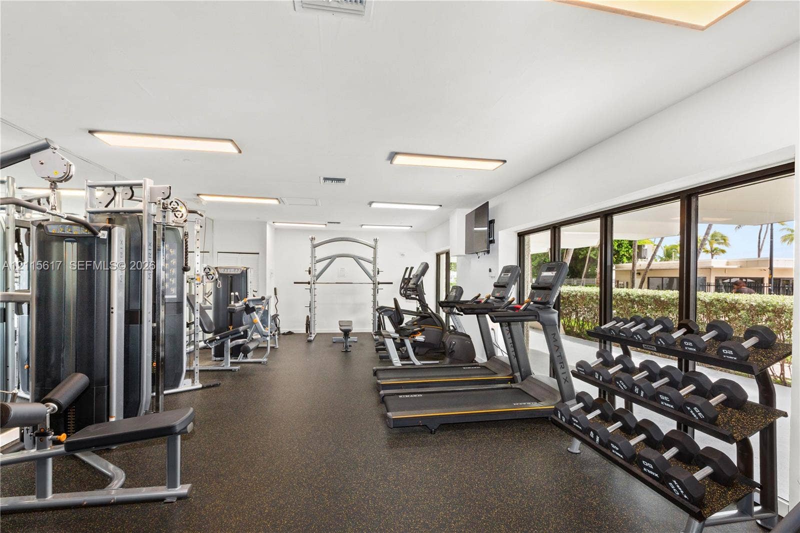 Fitness center featuring rubberized flooring, recessed lighting, and floor-to-ceiling windows