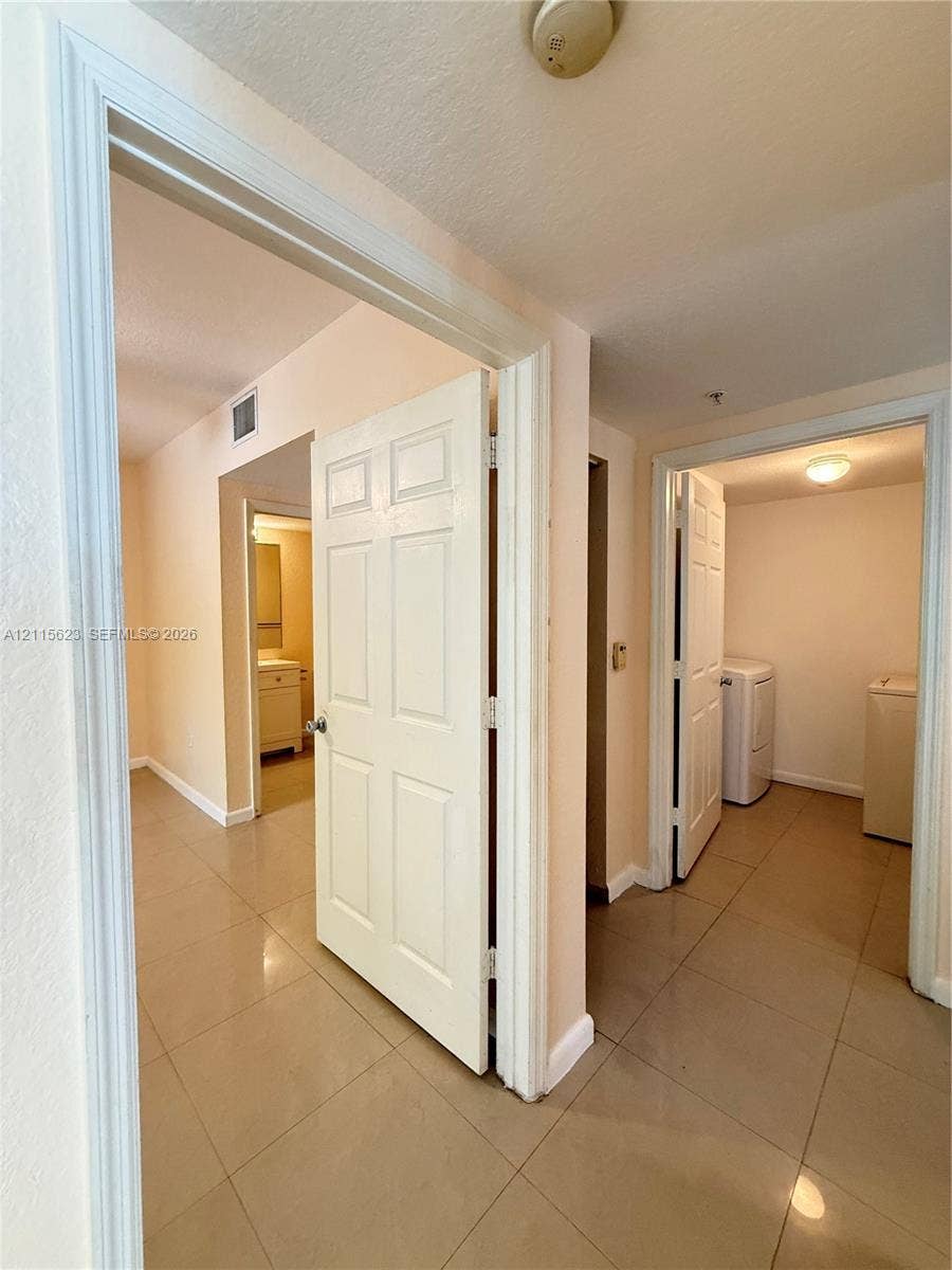 6796 W Sample Road, #6796, Coral Springs, Coral Springs, FL 33067 Interior hallway featuring neutral-toned tile flooring and six-panel interior doors
