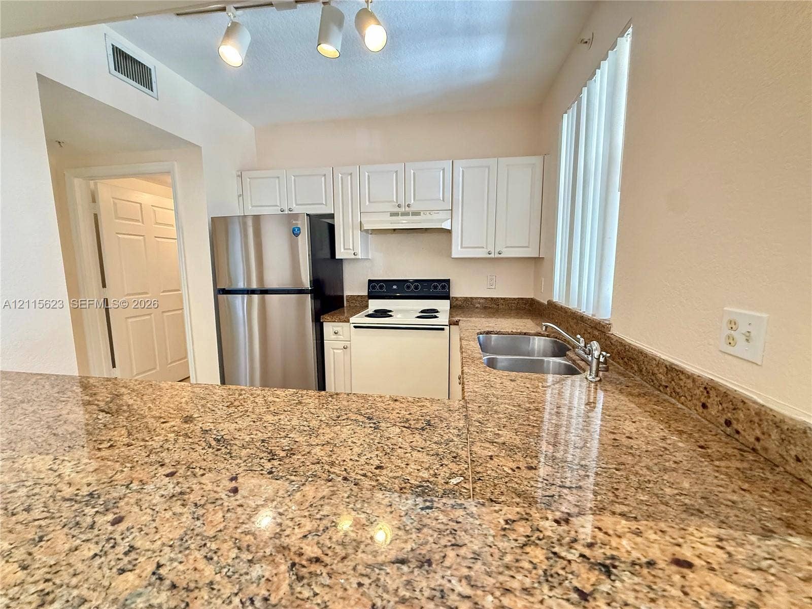 6796 W Sample Road, #6796, Coral Springs, Coral Springs, FL 33067 Kitchen featuring stone countertops, white cabinetry, a stainless steel refrigerator, a white electric range, and a dual-basin stainless steel sink