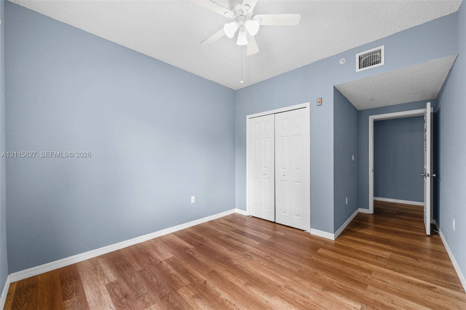7085 Nova Drive, #218, Davie, FL 33317 Room featuring wood-finish flooring, a ceiling fan with integrated lighting, and a double-door closet