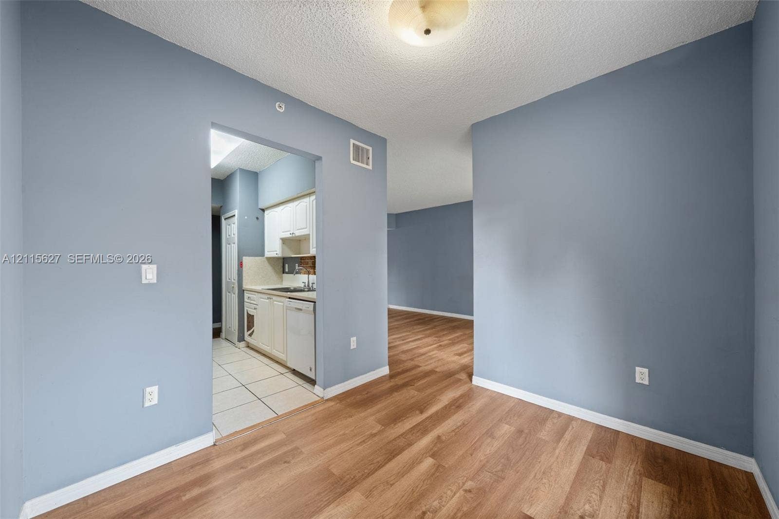 7085 Nova Drive, #218, Davie, FL 33317 Interior space featuring blue painted walls, wood-finish flooring, and a flush-mount ceiling fixture