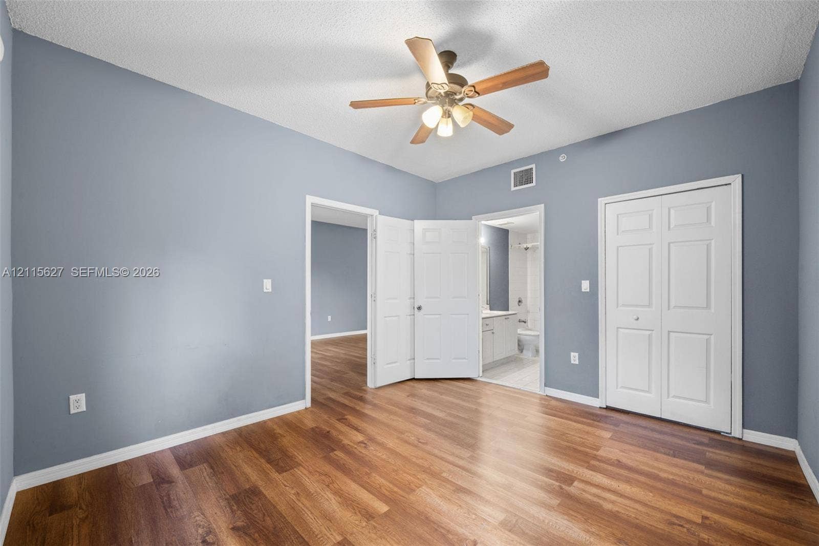 7085 Nova Drive, #218, Davie, FL 33317 Room featuring wood-finish flooring, a ceiling fan with integrated lighting, dual-panel interior doors, and a double-door closet