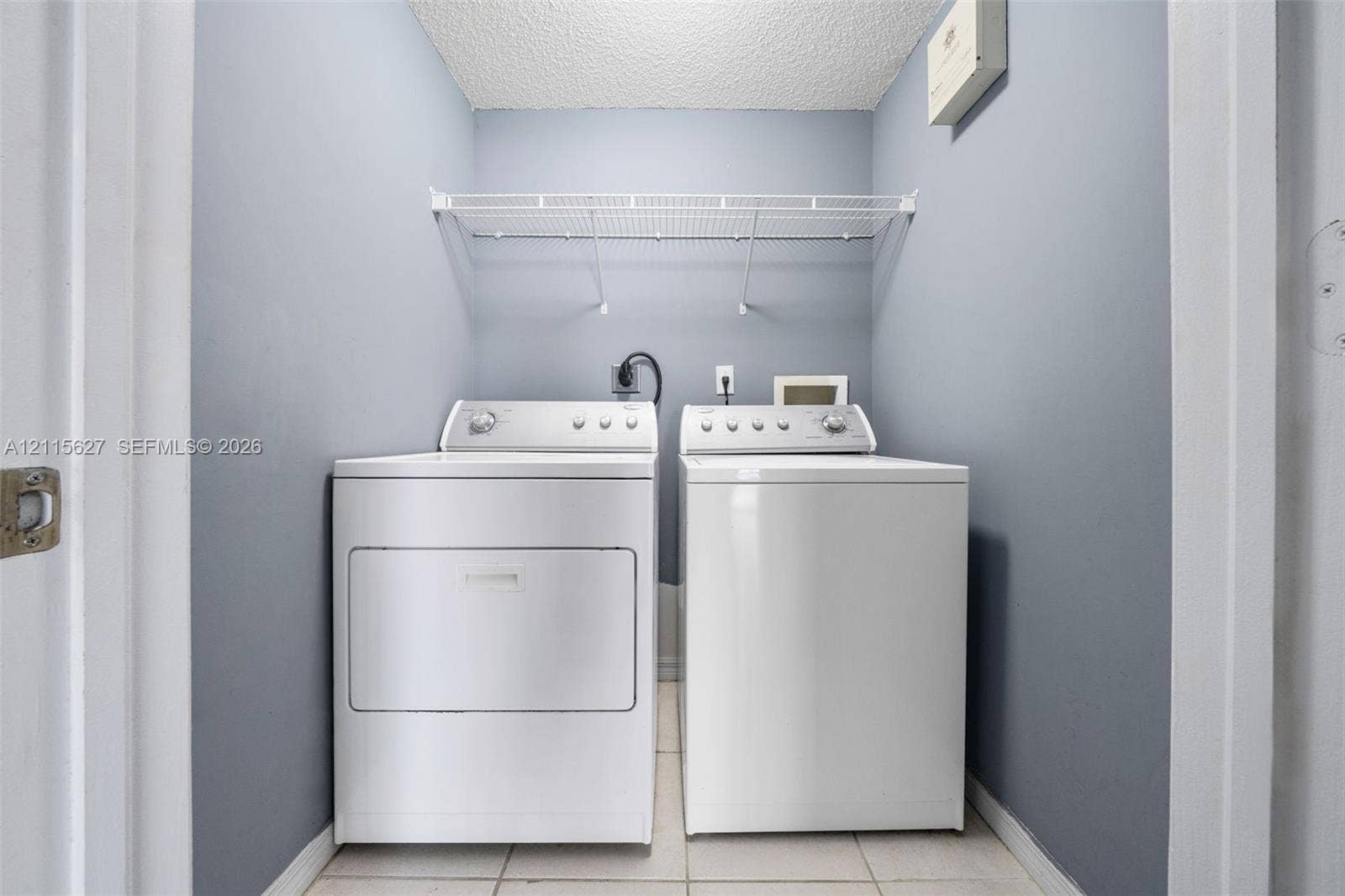 7085 Nova Drive, #218, Davie, FL 33317 Dedicated laundry alcove featuring tile flooring and overhead wire shelving