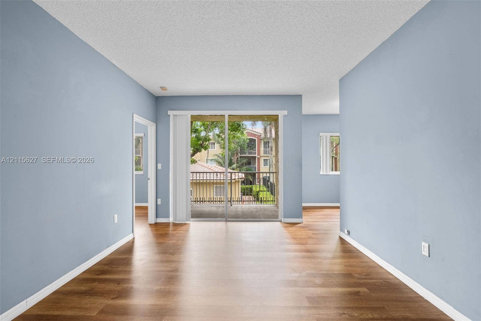 7085 Nova Drive, #218, Davie, FL 33317 Wood-finish flooring, sliding glass patio door, and exterior balcony
