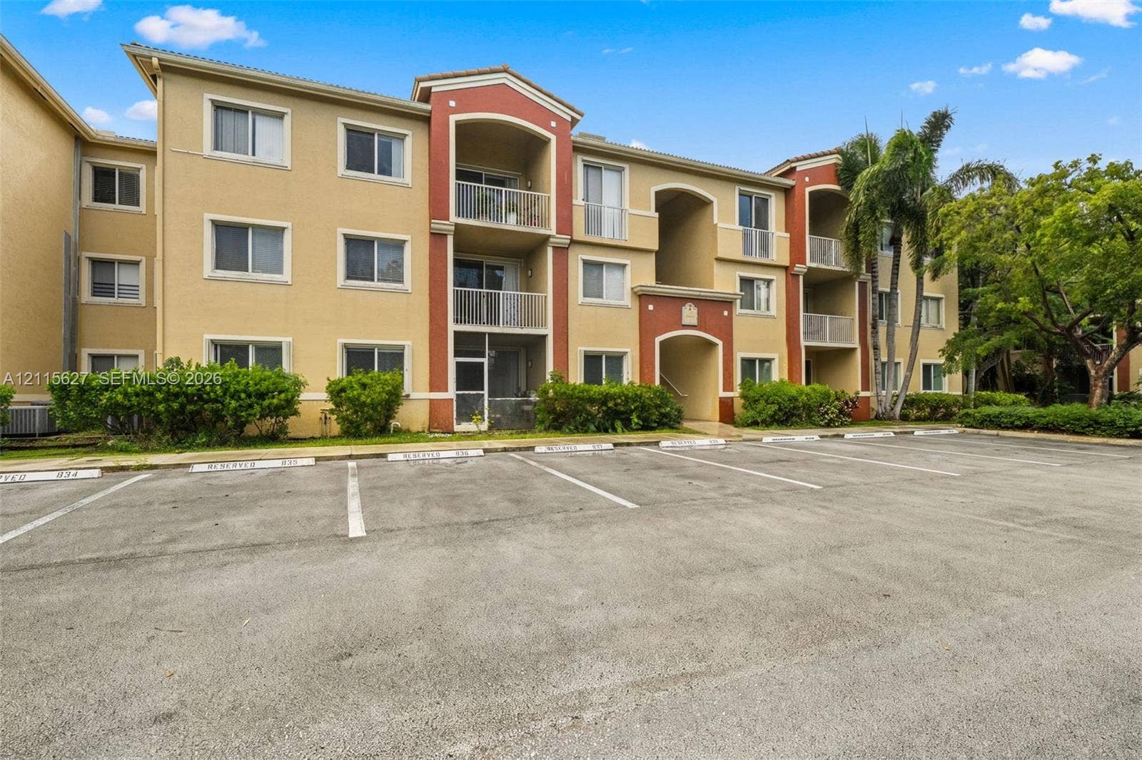 7085 Nova Drive, #218, Davie, FL 33317 Multi-story residential building featuring stucco exterior, private covered balconies, and dedicated surface parking