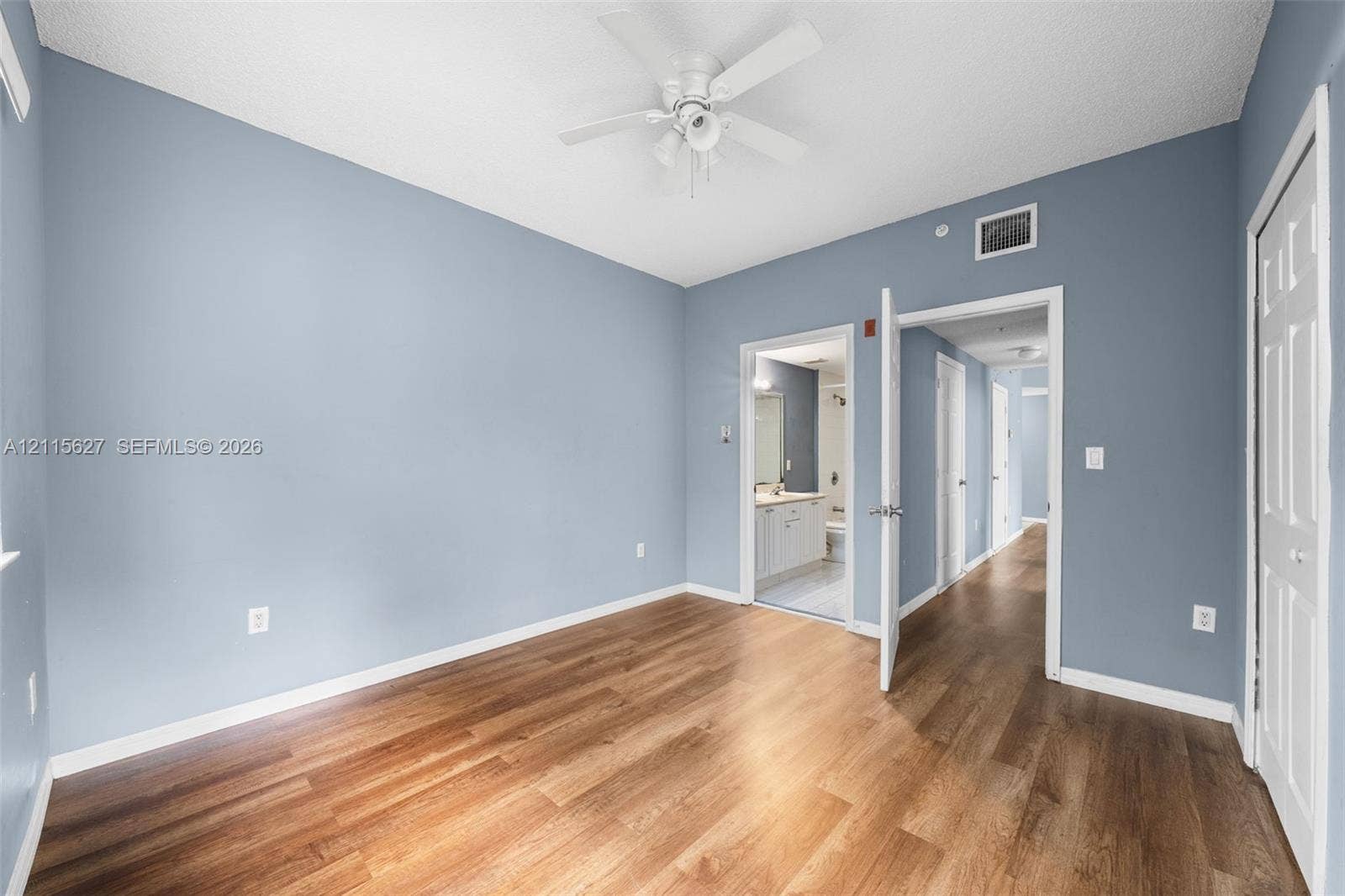 7085 Nova Drive, #218, Davie, FL 33317 Room featuring wood-finish flooring, a white ceiling fan with integrated lighting, and painted walls