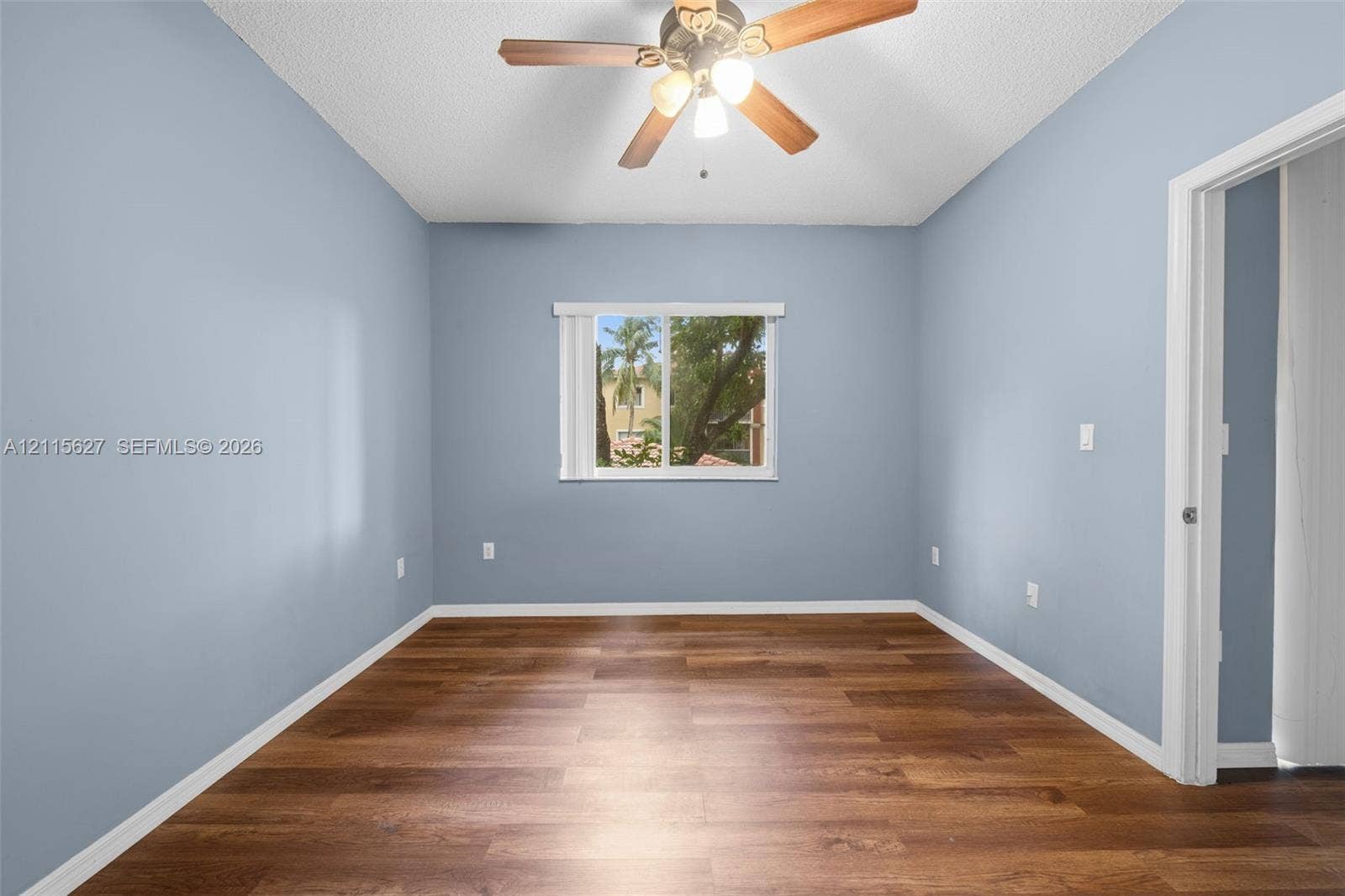 7085 Nova Drive, #218, Davie, FL 33317 Wood-finish flooring, ceiling fan with integrated lighting, and a window with exterior scenery