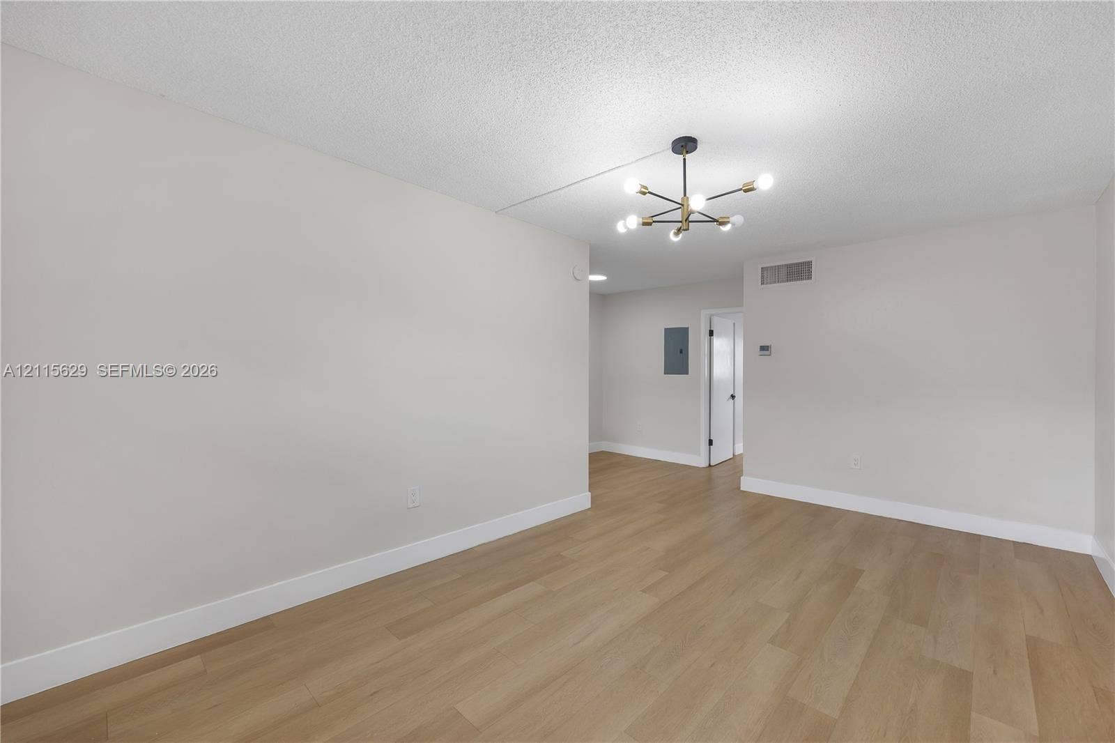 Interior space featuring wood-finish flooring, a contemporary multi-arm sputnik-style chandelier, and neutral wall tones