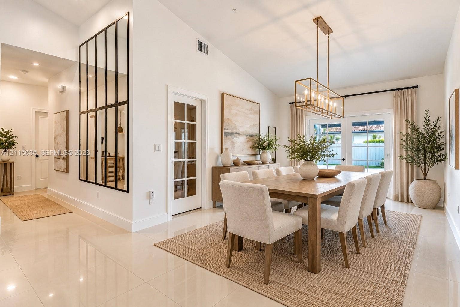15374 SW 113th Terrace, Miami, FL 33196 Vaulted ceilings, large-format tile flooring, metal-framed decorative mirror, glass-paneled interior door, and rectangular metallic chandelier