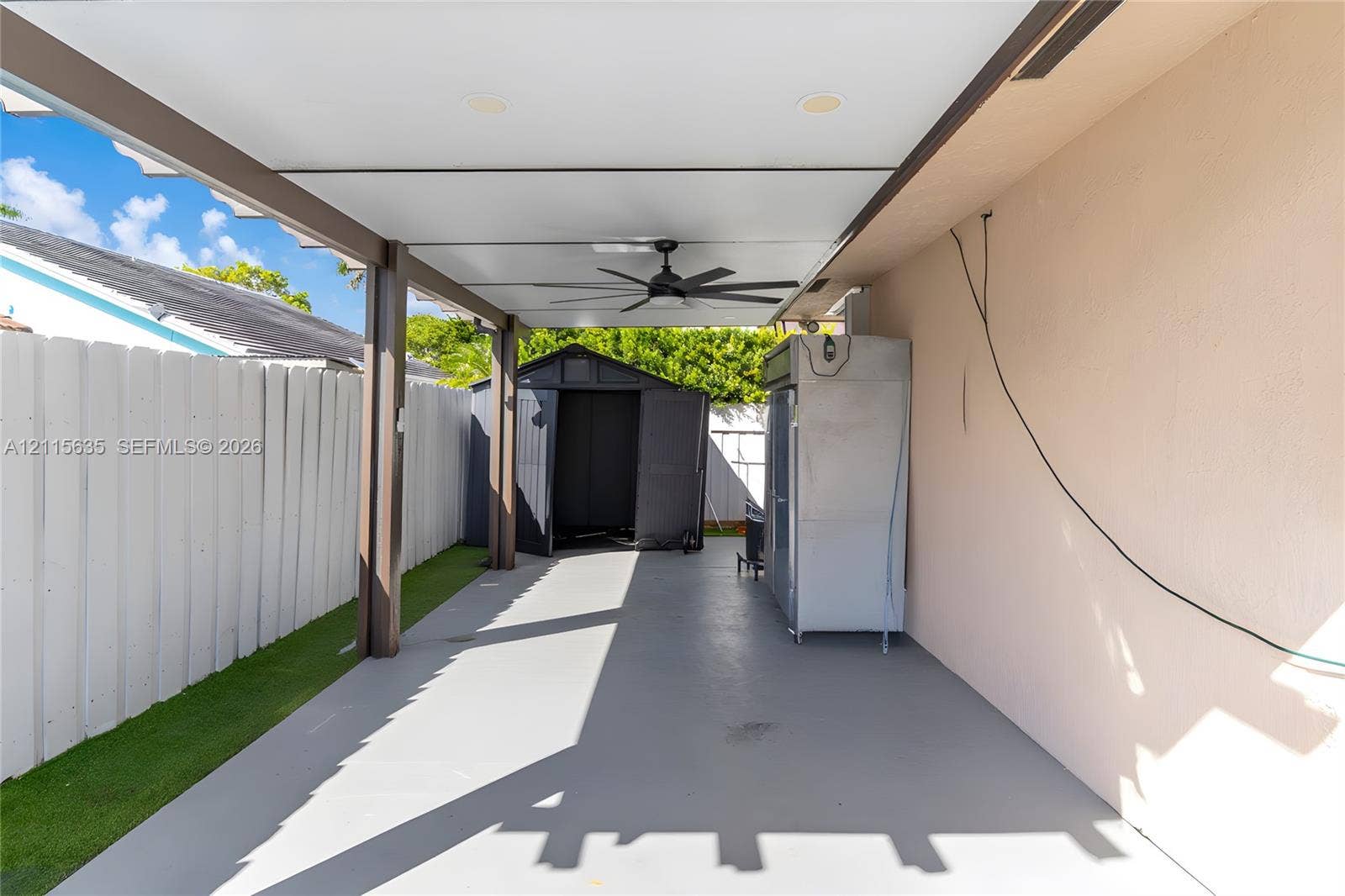 15374 SW 113th Terrace, Miami, FL 33196 Covered patio featuring a concrete floor, recessed lighting, and a ceiling fan, enclosed by a white vertical fence