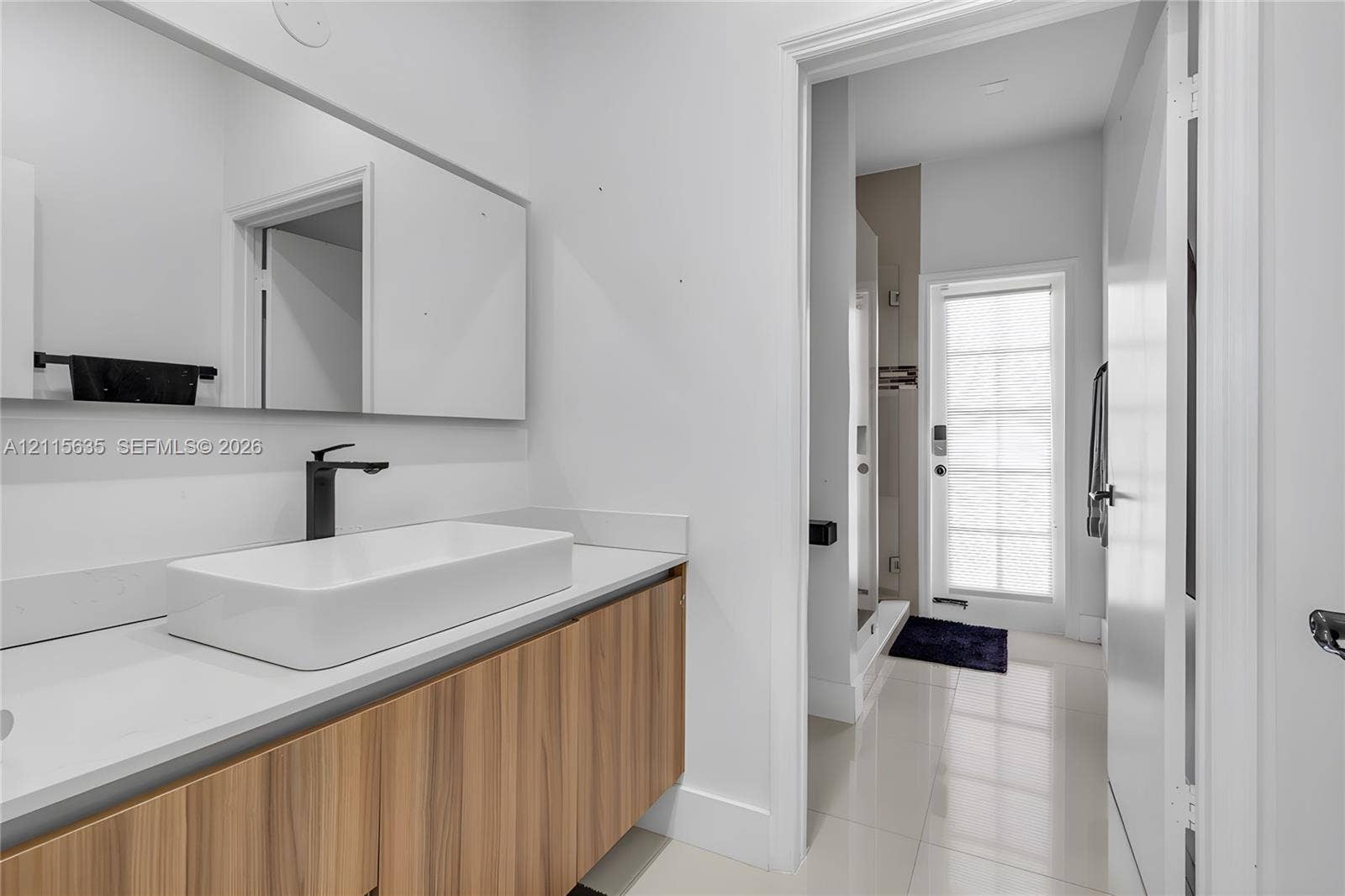 15374 SW 113th Terrace, Miami, FL 33196 Floating wood-finish vanity with white countertop, rectangular vessel sink, matte black faucet, and large wall-mounted mirror