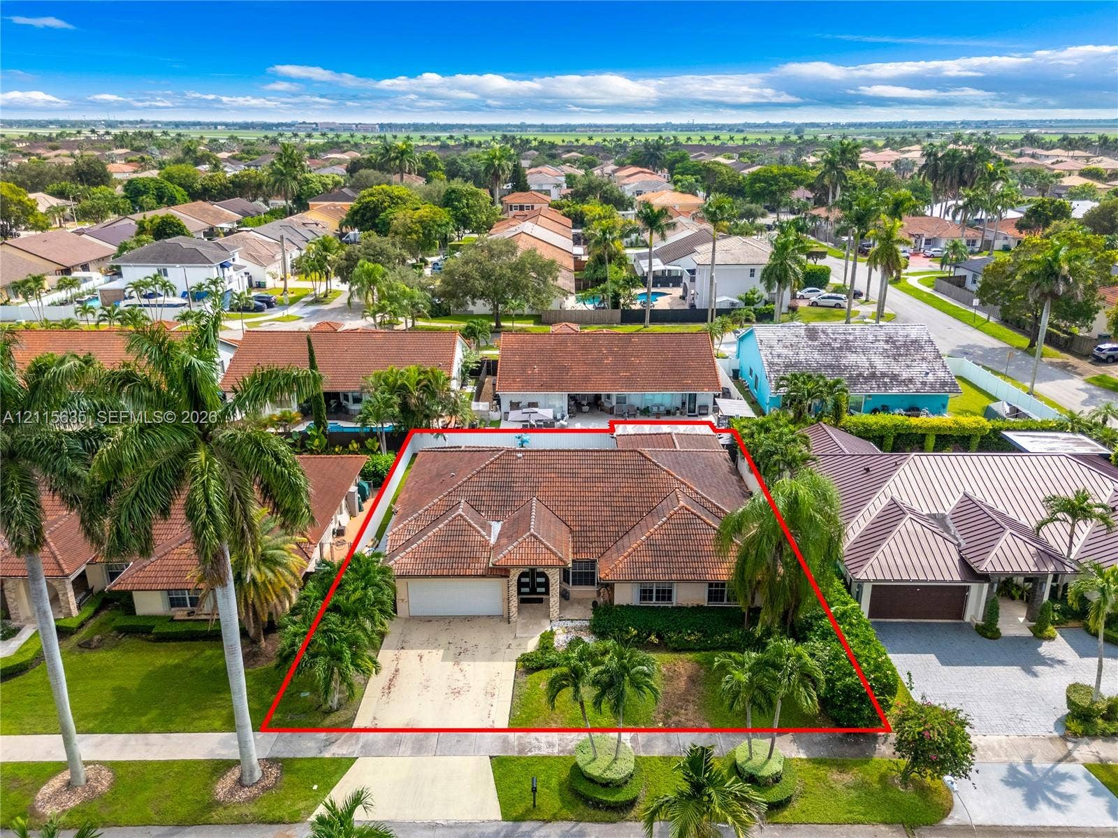 15374 SW 113th Terrace, Miami, FL 33196 Single-story residence featuring a tile roof, stucco exterior, two-car garage, and established landscaping with palm trees