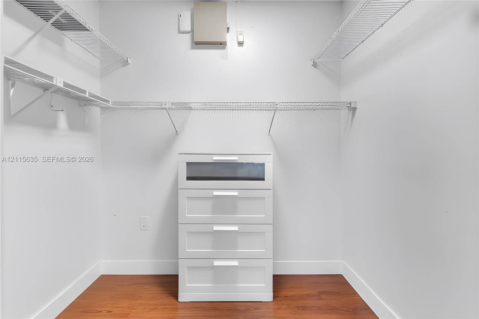15374 SW 113th Terrace, Miami, FL 33196 Walk-in closet featuring wood-finish flooring, white built-in four-drawer dresser, and tiered wire shelving