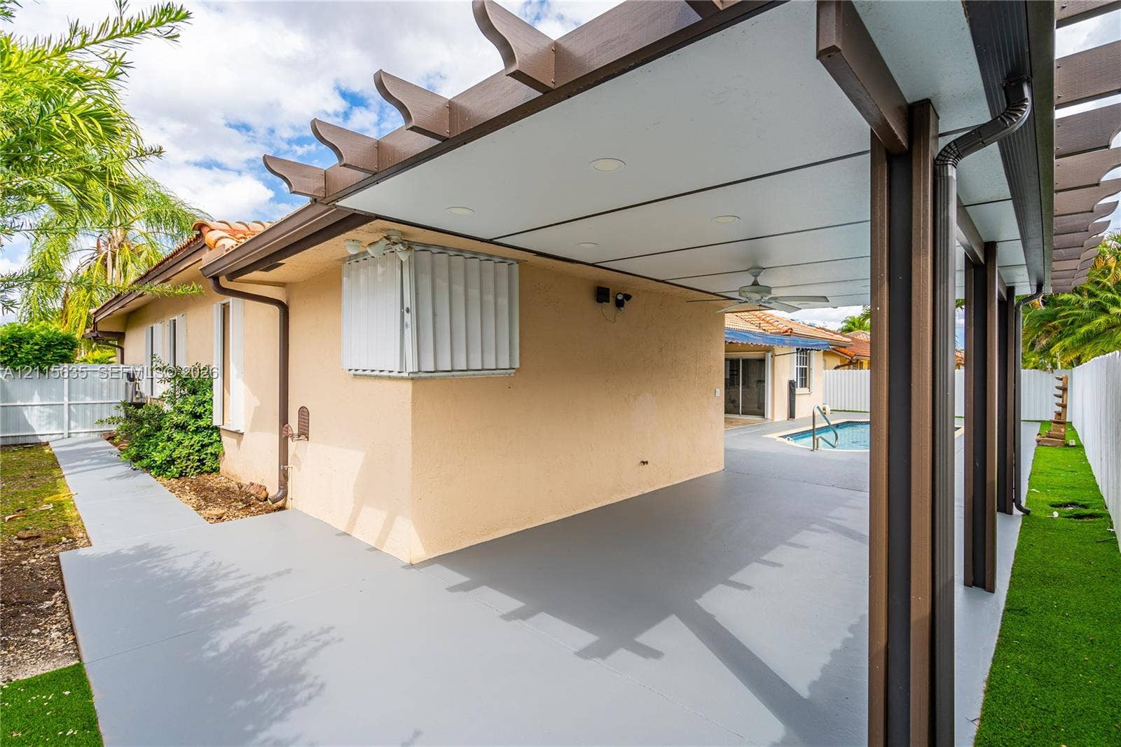 15374 SW 113th Terrace, Miami, FL 33196 Covered outdoor patio featuring a pergola-style roof structure, recessed lighting, ceiling fan, and painted concrete flooring