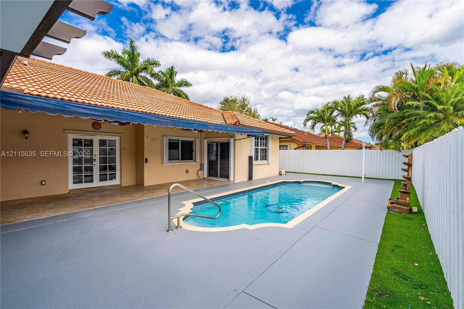 15374 SW 113th Terrace, Miami, FL 33196 In-ground pool with stone coping, covered patio, tile roof, and enclosed privacy fencing