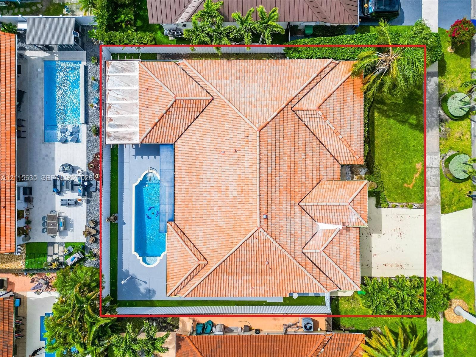 15374 SW 113th Terrace, Miami, FL 33196 Aerial perspective of a residential property featuring a tiled roof, an in-ground swimming pool with an integrated spa, a concrete pool deck, and a fenced backyard with established landscaping