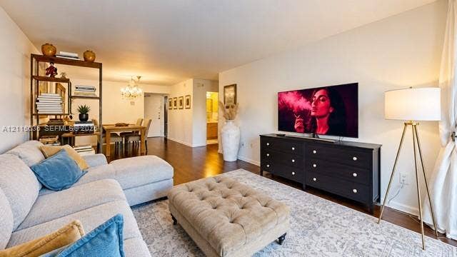 3860 NE 170th Street, #310, North Miami Beach, FL 33160 Open-concept interior featuring wood-finish flooring and a multi-arm crystal chandelier