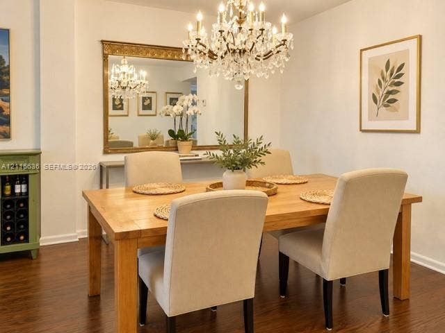 3860 NE 170th Street, #310, North Miami Beach, FL 33160 Formal dining area featuring wood-finish flooring, a crystal chandelier, and a large wall-mounted mirror with an ornate gold frame