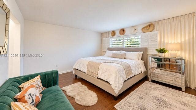 3860 NE 170th Street, #310, North Miami Beach, FL 33160 Wood-finish flooring, horizontal window blinds with louvered shutters, and ceiling-height window drapery